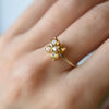 Woman with a Greenwich ring featuring four 4 mm faceted round cut citrines and one 2.1 mm diamond prong set in 14k gold