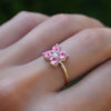 Woman with a Greenwich ring featuring four 4 mm faceted round pink tourmalines & one 2.1 mm diamond prong set in 14k gold