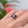 Woman's hand with a Greenwich ring featuring four 4 mm faceted round cut sapphires and one 2.1 mm diamond prong set in 14k gold