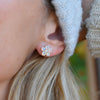 Close-up of a woman's ear wearing a single Greenwich Flower Opal & Diamond earrings featuring five 4mm prong set gemstones.