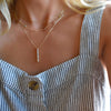 Woman wearing an Adelaide Mini necklace, personalized Classic 6 Birthstone necklace, and Providence 6 Aquamarine pendant.