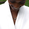 Woman wearing a Bristol Bead necklace featuring one center 8mm Milky Aquamarine bead and two 6mm gold beads on either side.