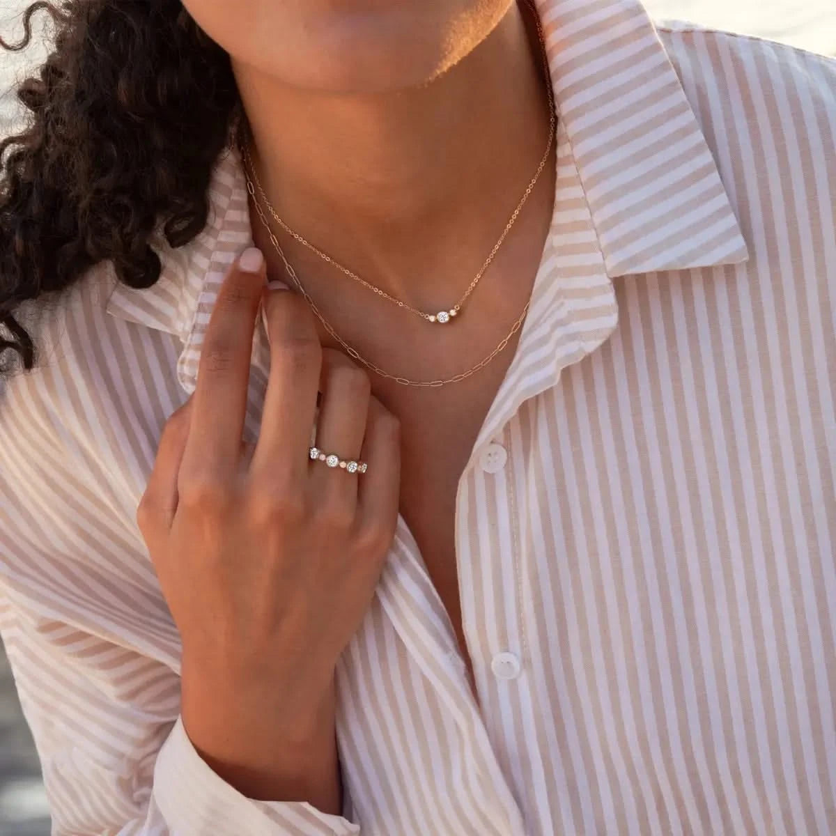 Woman wearing Barrington Diamond Necklace and matching Barrington Diamond Band Ring, both in 14k yellow gold.