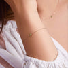 Woman with a Classic cable chain bracelet featuring one 4 mm briolette cut peridot bezel set in 14k gold