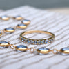 Close-up view of a Rosecliff Stackable ring and Newport necklace featuring Aquamarine gemstones in 14k yellow gold.