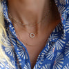 Woman wearing a Newport White Topaz necklace, Rosecliff Small Circle Diamond necklace, and Adelaide Mini necklace.