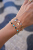 Woman's wrist wearing two personalized Newport Grand bracelets, MAMA bracelet, & personalized Classic 5 Birthstone bracelet.