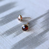 Pair of 14k yellow gold Grand stud earrings each featuring one 6 mm briolette cut bezel set garnet