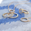 Two Rosecliff Circle necklaces and three Rosecliff rings, all featuring sustainably grown diamonds in 14k yellow gold.