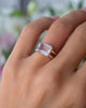 Woman's finger wearing a Warren Horizontal Rose Quartz ring featuring a bezel set center stone on a tapered split shank band.