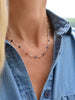 Woman wearing a Newport Wisdom necklace featuring a continuous strand of alternating bezel set sapphires and moonstones.