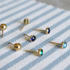 Scattered assortment of Classic stud earrings featuring sapphire, emerald, and Nantucket blue topaz, & Bristol stud earrings.