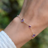 A woman wearing a Bayberry Grand & Classic 7 Amethyst Bracelet in 14k white gold featuring 6mm and 4mm gemstones.