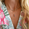 A woman wearing a Newport Aquamarine necklace, a Providence 3 Alexandrite pendant, and an Adelaide necklace.
