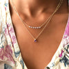 A woman wearing a Rosecliff Diamond & Amethyst Bar necklace and a Greenwich Solitaire Amethyst & Diamond necklace.