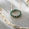 A Rosecliff Circle necklace featuring sixteen 2mm faceted round cut, prong set sustainably grown emeralds in 14k yellow gold.