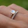 Woman's hand with two stacked rings consisting of a Grand Moonstone ring and a Rosecliff Diamond Stackable ring.