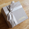 Signature gift box with the Haverhill logo in gold lettering on the bottom right, tied with a gray, satin ribbon bow.