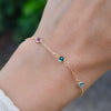 Close-up of woman's wrist wearing a personalized Classic 3 Birthstone bracelet featuring three 4mm briolette cut gemstones.