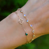 Woman wearing a personalized Gemini & Birthstone bracelet on Adelaide Mini chain featuring a zodiac cutout & 4mm gemstone.