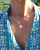 Woman wearing a personalized Flat Heart pendant on Adelaide Mini chain featuring a 16x15mm heart engraved with the letter H.