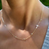 Woman wearing a 14k yellow gold 1.17mm cable chain necklace featuring four 4mm gemstones and one 0.5in cutout cross.