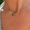 Woman wearing a personalized Grand 2 Connected necklace featuring emerald and aquamarine on a 1.17mm cable chain.
