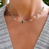 Woman wearing a personalized Grand 9 Birthstone necklace featuring alternating 6mm briolette cut emeralds and moonstones.