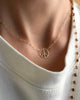 Woman wearing a Large Peace Sign Adelaide Mini necklace featuring a 0.5in cutout peace symbol on a paperclip link chain.