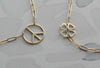 Close-up of two cutouts on separate Adelaide Mini chains including a 0.5in large peace symbol and 9.1mm four-leaf clover.