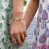 A mother wearing a personalized Newport Grand bracelet, a letter bracelet, a Warren ring, and 3 Rosecliff rings.