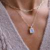 Woman layering an Adelaide necklace and Warren Rainbow Moonstone pendant on an Adelaide Mini chain in 14k yellow gold.