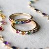 Two Rosecliff Rainbow Stackable rings in 14k yellow gold featuring a rainbow-hued pattern, one with alternating diamonds.