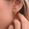 Woman's ear with a 13 x 13mm Rainbow Rosecliff earring featuring nine 2mm faceted round cut, prong set gemstones.