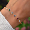 Close-up of woman's wrist wearing a Rainbow Newport bracelet featuring 4mm briolette cut, bezel set gemstones.