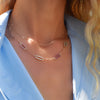 Woman wearing an Adelaide Mini necklace and personalized Adelaide 4 Pavé Link Birthstone necklace in 14k yellow gold.