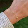 Close-up of a wrist wearing a Bayberry 3 Peridot bracelet featuring 4mm briolette cut gemstones on a 1.17mm cable chain.