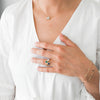 A woman wearing a 14k yellow gold White Topaz Greenwich Flower necklace, 3 Grand rings, and 2 Bayberry bracelets.