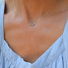 Woman with a Grand 14k yellow gold 1.17 mm cable chain necklace featuring one 6 mm briolette cut bezel set aquamarine