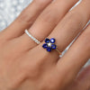 Woman wearing two rings including a Greenwich ring featuring five 4 mm sapphires and one 2.1 mm diamond prong set in 14k gold