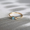 A Greenwich ring featuring one 4 mm Blue Topaz and one 2.1 mm Diamond prong set in 14k gold