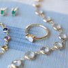 Jewelry including a Greenwich ring featuring one 4 mm faceted Solitaire Opal and one 2.1 mm diamond prong set in 14k gold
