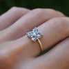 Hand wearing a Greenwich ring featuring four 4 mm faceted round Aquamarines and one 2.1 mm Diamond prong set in 14k gold.