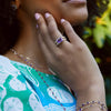 Woman's hand displaying the 14k gold Warren Horizontal Amethyst Ring with Diamonds, featuring an 8 x 10mm amethyst and 16 prong-set diamonds.