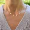 Woman wearing a custom personalized NANA necklace with two gemstones on each side featuring 0.25 flat discs & 4mm gemstones.