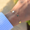 Woman's wrist wearing 2 Letter & 2 Birthstone bracelet featuring .25in flat engraved letter discs and two 4mm gemstones.