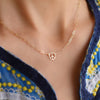 Woman wearing a Peace Sign Adelaide Mini necklace featuring a 7.2mm flat cutout peace sign on a paperclip link chain.