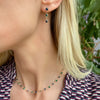 Woman wearing a single Terra 3 Stone drop earring and Terra Newport necklace in 14k yellow gold - angled side view.