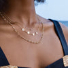 Woman wearing a Classic 1 necklace, MAMA necklace on 1.17mm cable chain, and a Newport necklace featuring 4mm gemstones.