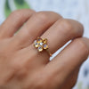 Close-up of a finger wearing a Greenwich Flower ring featuring five 4mm citrine gemstones and one 2.7mm center diamond.